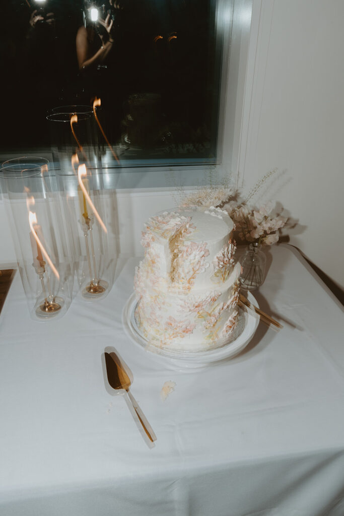 Blurry photo of a wedding cake that's been cut and candles